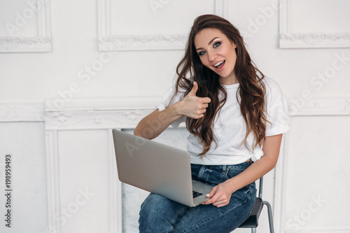 Fotografie, Obraz happy girl after a successful transaction rejoices and looks at the computer show goog, ok sign