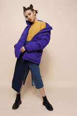 Wall Mural - Young fashion woman in short violet down jacket.