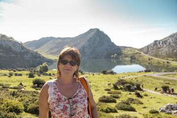 Woman portrayed before a view of Lake Enol in the natural park of the lakes of Covadonga in Picos de Europa, Asturias, Spain