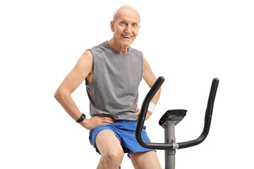 Sticker - Senior on an exercise bike looking at the camera and smiling