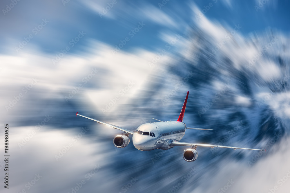 Modern airplane mith motion blur effect at sunny bright day. Landscape with passenger airplane, blurred clouds, mountains, blue sky. Passenger aircraft in motion. Business travel. Commercial plane - obrazy, fototapety, plakaty 