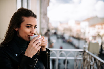 Wall Mural - Close-up image of a cute girl relaxing on the terrace with a cup of coffee.