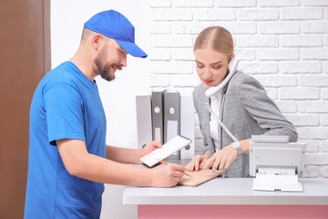 Canvas Print - Female receptionist receiving parcel at workplace