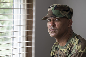 Portrait of a black man in military fatigues, looking at the camera