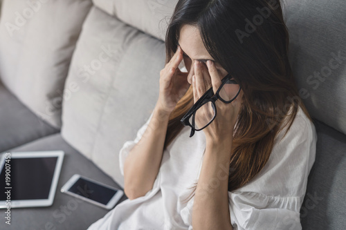 Fotografie, Obraz Young woman take off her glasses and siiting on sofa