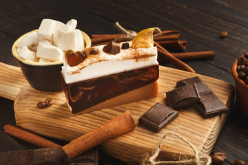 Various sweet treats: cakes and chocolate bars on dark rustic table, side view