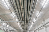 Fototapeta Miasto - Industrial metal pipes along the ceiling, ventilation system