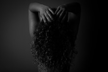 Low Key Black And White Portrait Of A Curly Hair Woman From Behind