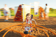 © Ilshat - little girl spinning on a children's carousel among the playground.