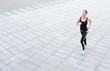 © Prostock-studio - Young woman jogging in city copy space