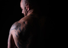 Muscle Brutal Athlete With Tattoos Posing In The Studio And Performing Physical Exercises