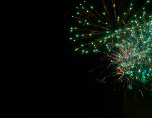 Colorful bright green fireworks and smoke in the night sky background