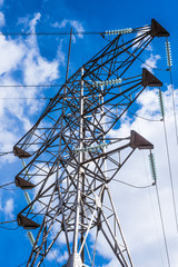 Wall Mural - Tower high-voltage transmission lines against the blue sky with white clouds