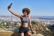 © Joshua Resnick - fit african american woman taking selfies at runyon canyon with los angeles in background