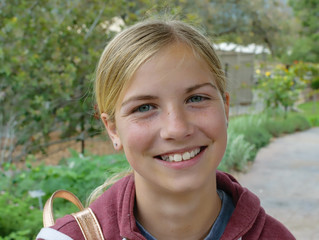 Young female smiles happily in outdoor portrait