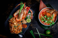 Concept Pictures Of Famouse Thai Dishes, Tom Yum Kung & Phad Thai. Beautiful Presentation On Black Stone And Black Background.