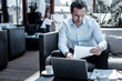 © Viacheslav Yakobchuk - Business project. Serious nice smart businessman sitting in front of his laptop and holding a document while working