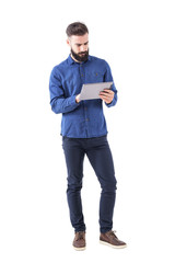 confident serious bearded business man using tablet touch pad screen. full body isolated on white ba