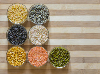 7 bowls of lentils on a chopping board