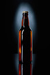 Closed bottle of beer on a black background.