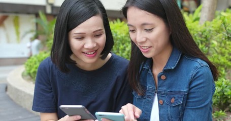 Poster - Woman friends talking on cellphone together at outdoor