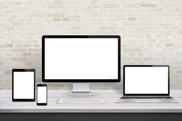 Poster - Multiple display devices for responsive web desing promotion. Modern office desk with brick wall in background.