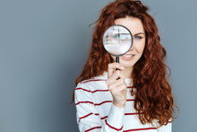 Laboratory Equipment. Close Up Of Magnifying Glass Being In Hands Of A Cheerful Smart Red Haired Woman While Doing A Research