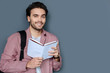 © zinkevych - Pleasant trips. Cheerful handsome bearded tourist smiling and looking at you while holding a travel guide