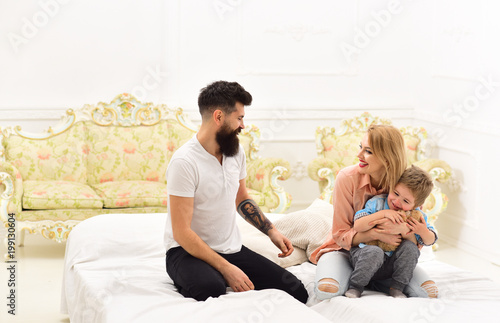 Young Family Spend Time Together On Bed Luxury Interior