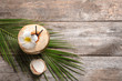Beautiful composition with fresh green coconut and palm leaf on wooden background
