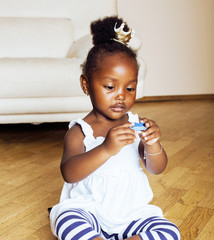 little cute african american girl playing with animal toys at ho