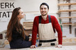 © Rithor - young happy family standing at a work bench in a carpentry workshop, writing a project. Family business. startup business. young specialist designer.