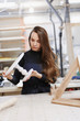 © Rithor - Portrait of cheerful young woman working in carpenters shop. Family business. startup business. young specialist designer.