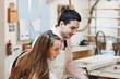 © Rithor - young happy family standing at a work bench in a carpentry workshop, writing a project. Family business. startup business. young specialist designer.