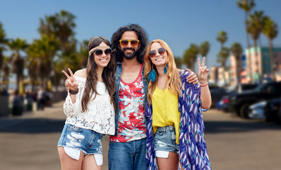 Sticker - summer holidays, youth culture, gesture and people concept - smiling young hippie friends in sunglasses showing peace hand sign over venice beach in los angeles background