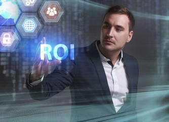 Business, Technology, Internet and network concept. Young businessman working on a virtual screen of the future and sees the inscription: ROI