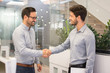 © Bojan - Two smiling businessmen shaking hands together in office