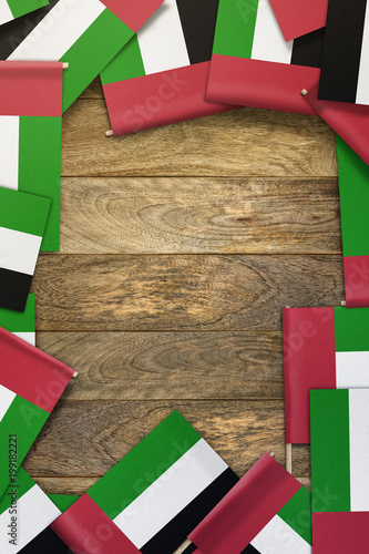 Fotografie, Obraz United Arab Emirates small flags framing a wood texture background with copy spa