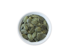 Wall Mural - pumpkin seeds isolated on white background. Top view. Pumpkin seeds in a bowl isolated on white background. Pumpkin seeds with copy space for text.