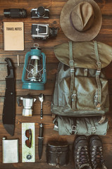 Wall Mural - camping stuff arranged on wooden backdrop. machete, boots, lantern, camera, hat, map, compass. getti