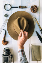 Wall Mural - adventure planning flat lay. travel vintage gear on map. traveler, explorer hands in frame taking or