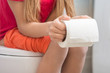 A girl is holding a roll of toilet paper in her hands, sitting on the toilet
