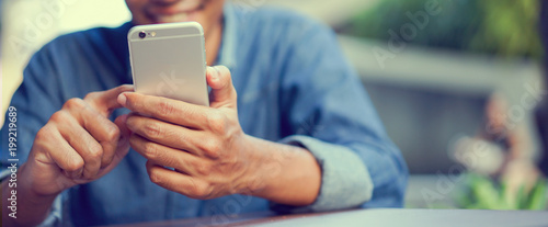 Cuadros en Lienzo close up hand hold mobile cell phone device:focus on man play on smartphone con