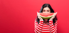 Happy Young Woman Holding Watermelon On A Red Background