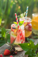 Wall Mural - Fresh fruit and berry water in glass jars. Concept for healthy eating and nutrition. Selective focus.