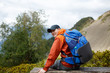 © Sergey - Photo of sporty smiling man with backpack on background of mountain