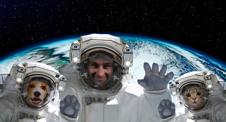 Wall Mural - portrait of a spaceman with a dog and a cat on the background of the globe. elements of this image f