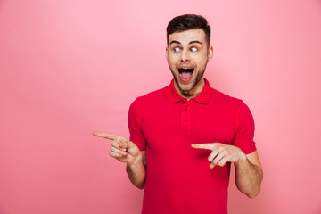 Wall Mural - Portrait of a joyful young man pointing fingers away