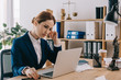 © LIGHTFIELD STUDIOS - female lawyer in suit working on laptop at workplace in office