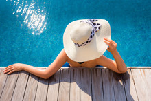 Sexy Woman In Swimsuit Is Relaxing In Swimming Pool, Beautiful Asian Woman Wearing Straw Hat And Relax Sunbathe In Poolside On Summer Holiday At Resort Hotel, Leisure Activities And Relaxation Time